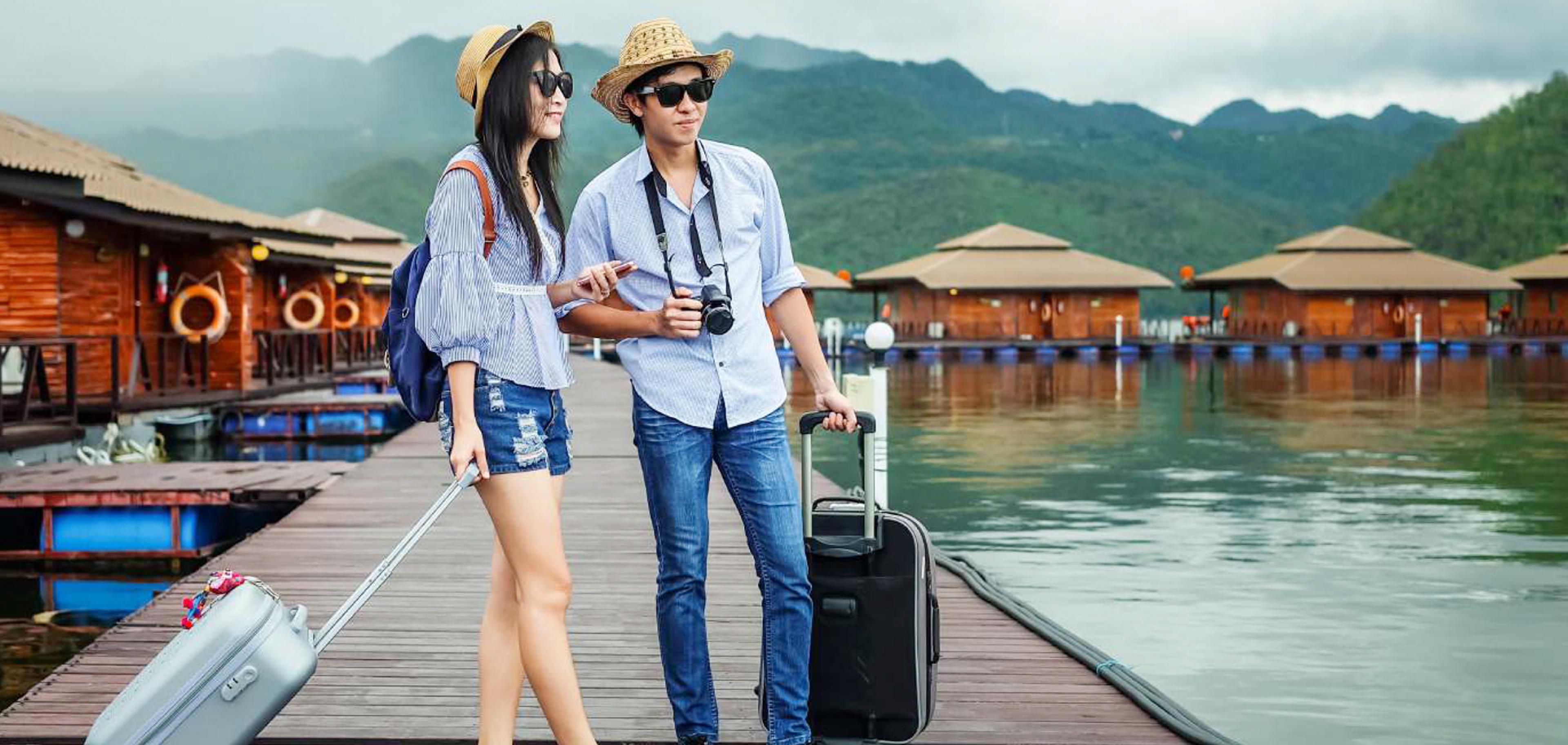 Couple walking along a pier toward overwater bungalows